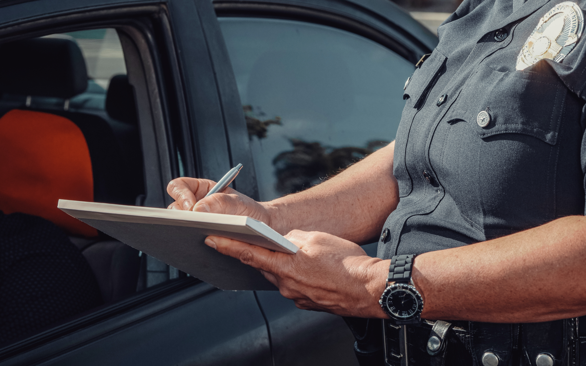 A police offer writes a traffic ticket